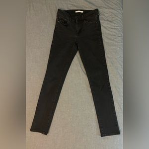Levi’s mid-rise skinny jeans in black, size 4.